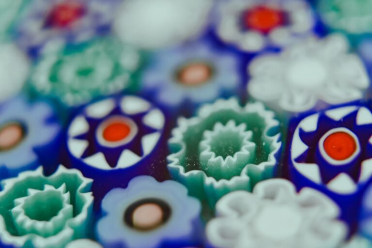 A close-up of multicoloured millefiori glass canes, showing the patterned cross-sections used to build paperweight designs.